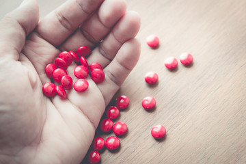 medicine pill on hand with wood table background
