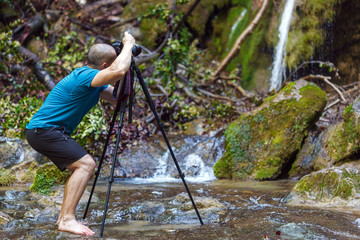 Obraz premium Professional landscape photographer shooting a waterfall