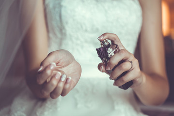 Bride's hands holding a bottle with parfumes - Powered by Adobe