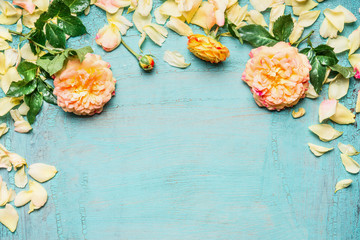 Yellow pink roses with leaves and petals on light blue background, top view, floral border