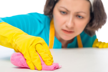 woman meticulously rubbing the white table a rag, hand closeup