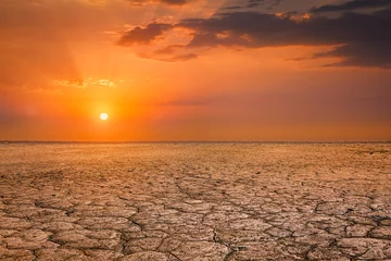 Photo sur Plexiglas Sécheresse Paysage de coucher de soleil de sol de terre craquelée
