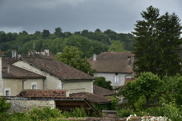 Fototapeta na wymiar Maisons rustiques de Champagne-et-Fontaine au milieu de la nature luxuriante sous un ciel gris au Périgord Vert