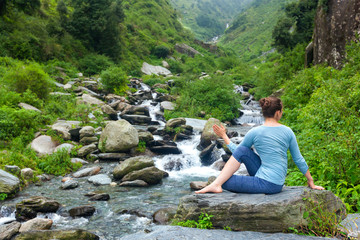 Naklejka premium Woman doing Ardha matsyendrasanaasana asana outdoors