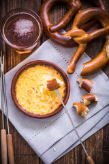 worming cheese fondue with pretzel at winter