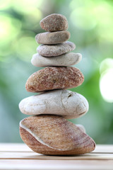 Fototapeta na wymiar balance rock or zen stones on wooden floor and have nature green