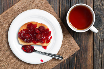 Tea and cherry jam with bread