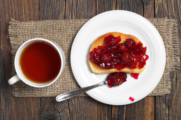Tea and cherry jam with bread