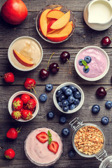 Homemade yogurt with fresh strawberry, blueberry, peach on a woo