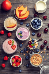 Homemade yogurt with fresh strawberry, blueberry, peach on a woo