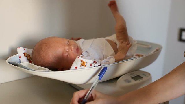 Newborn baby on a weight scale