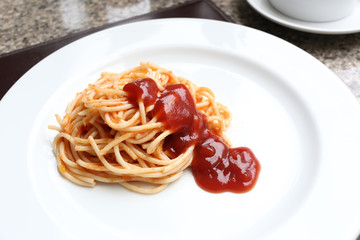 Spaghetti with tomato sauce on white dish.