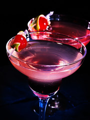 Top view of pomegranate cocktail glasses on black background. Alcohol cocktail decoration cherry.