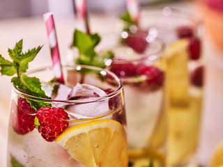 Three glasses with alcohol cocktail and ice cubes. Drink three hundred and twenty nine cocktail raspberry mohito with straw and lime and mint leaf.