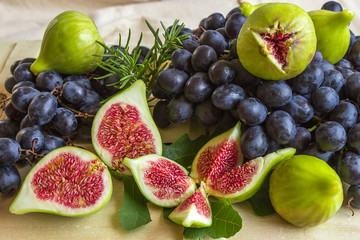 Still life of fresh colorful fruits. Bunch of black grapes, gree