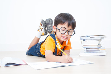 Naklejka na ściany i meble The boy writing homework from school in workbook 