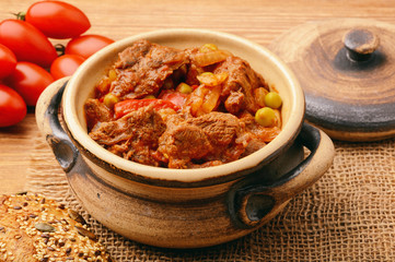 Venison goulash on brown wooden background. 