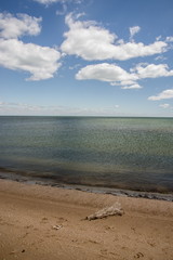 Calm sea, white clouds, yellow sand