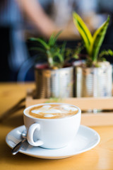 Coffee cup and flower decor on wooden background