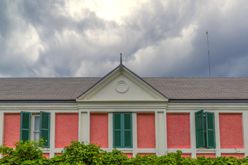 detail of wooden roof gable with clay roof tile on white cloudy sky