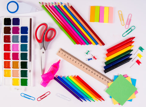 Color pencils and watercolors on white background, back to school, stationery flat lay