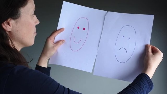 Young woman (age 30-35) choosing between happiness and sadness.Woman lifestyle concept. copy space