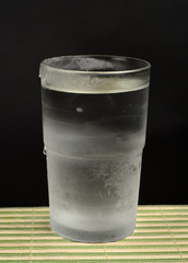 Glass of very cold, iced water on black background
