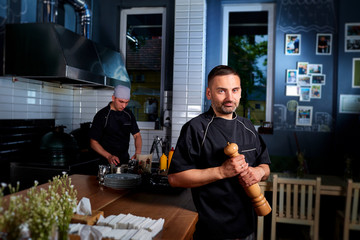 Portrait of a chef in a restaurant in a fashionable black unifor