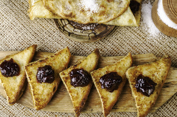 Toast with jam, sugar bowl and pancake on a plate.