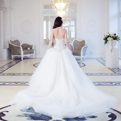 Beautiful bride. Wedding dress with open back. Luxurious light interior