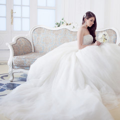 Fototapeta premium Portrait of beautiful laughing bride. Wedding dress with open back. Luxurious light interior
