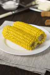 Homemade boiled corn on the wooden table.