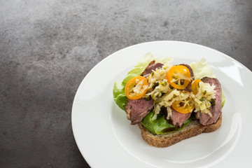 Toast mit Salat, Entenbrust, Apfel und Kumquat