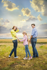 happy family mother, husband and daughter on a background of lake at rest