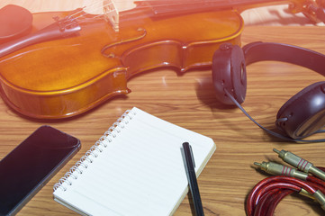 Violin phone notebook on wood background.hipster tone.