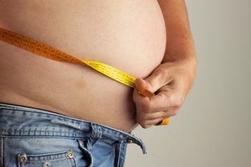 Obese fat man. Man is holding his too fat tummy. Obesity health hazard.
