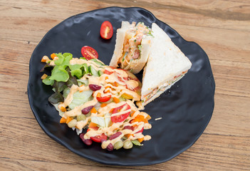 Sandwiches, salads, vegetables, sauce on the wooden floor.