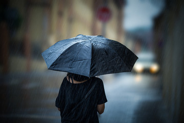 Girl walking with umbrella on rainy day