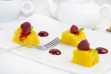 dessert of pineapple and decorated with raspberries on a white background