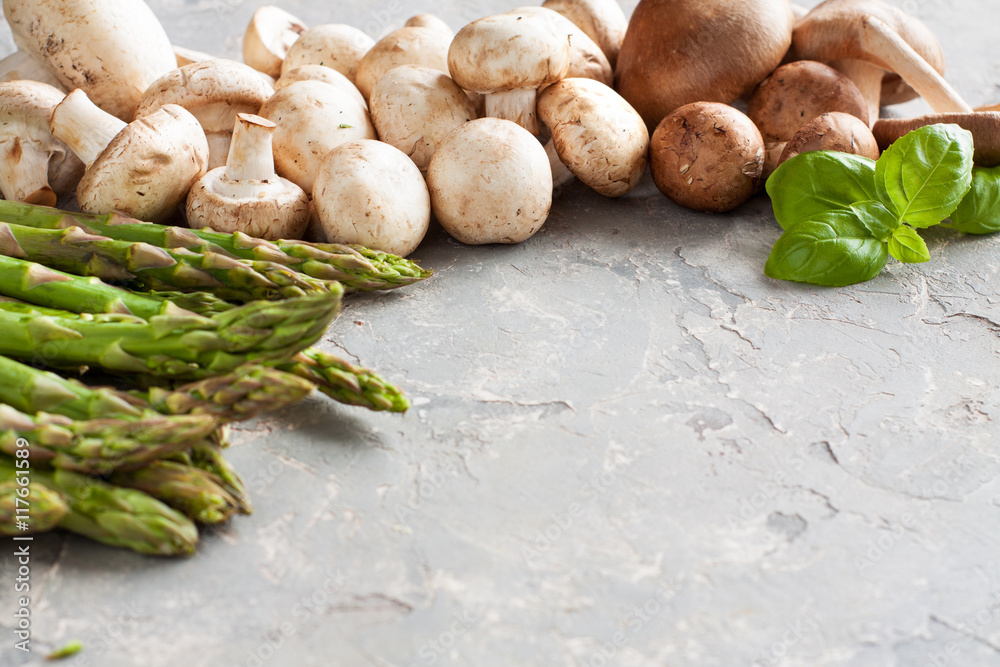 Wall mural Asparagus and champignons on stone background