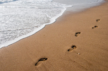 beach, waves and footsteps at sunset time