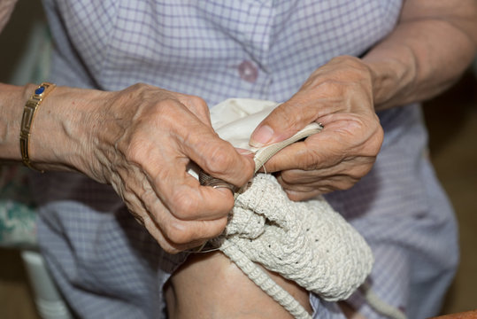 Details of a dressmaker weaving a cushion