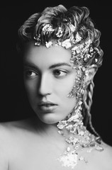 Portrait of beautiful fashion model with shiny foil on face and