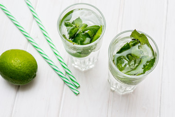 Summer drink,  mojito drink with ice, mint and lime on wooden table