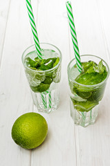Summer drink,  mojito drink with ice, mint and lime on wooden table