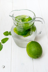 Summer drink,  mojito drink with ice, mint and lime on wooden table