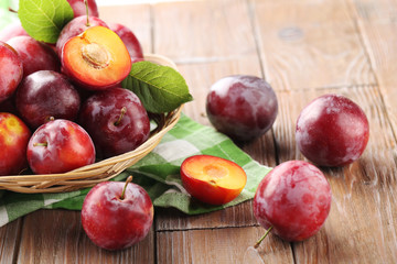 Fresh plums on a brown wooden table