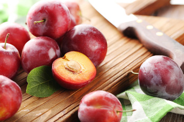 Fresh plums on a brown wooden table