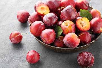 Fresh plums on a grey wooden table