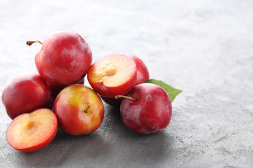 Fresh plums on a grey wooden table